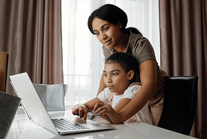 mom and daughter using laptop