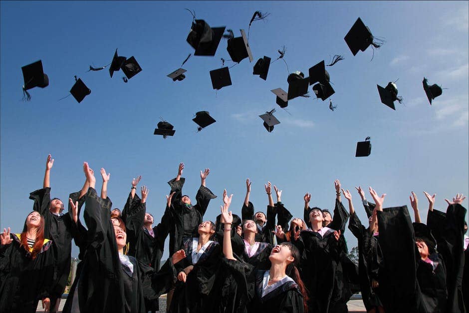 Graduate students tossing cap
